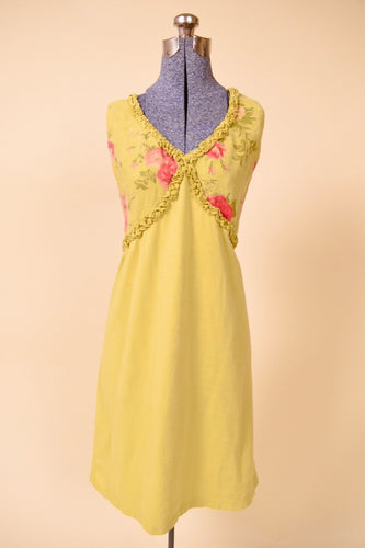 Vintage chartreuse green floral linen midi dress is shown from the front. This dress has a ruffle trim on the bust. 