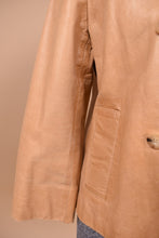 Load image into Gallery viewer, Vintage light tan cropped boxy leather jacket is shown in close up. This jacket has two front pockets. 

