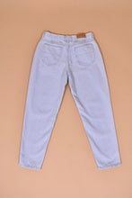 Load image into Gallery viewer, Vintage 1990s light wash denim blue jeans are shown from the back. These Riders jeans have a tapered mom jeans fit.
