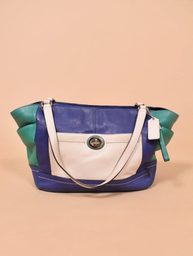 Vintage Y2K colorblock Carrie purse by Coach is shown from the front. This purse is made from a navy blue, green, and white leather. 