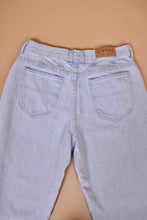Load image into Gallery viewer, Vintage 90s light blue denim mom jeans are shown from the back. These mom jeans have a high waisted fit.
