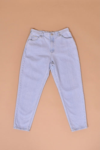 Vintage 1990's light blue denim mom jeans are shown from the front. These tapered light wash jeans are by Riders.