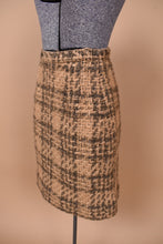 Load image into Gallery viewer, Vintage sixties Peck &amp; Peck fuzzy wool mini skirt is shown from the side. This mini skirt is made from a light tan material. 

