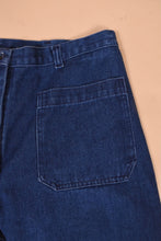 Load image into Gallery viewer, Vintage 70s dark blue flare jeans are shown in close up. These utility style jeans are a size 34 waist. 
