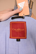 Load image into Gallery viewer, Vintage beige boxy leather jacket by Cole Haan is shown in close up. This jacket has a tag that reads Cole Haan Country. 

