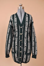 Load image into Gallery viewer, Vintage 1980&#39;s green and white vertical stripe long cardigan is shown from the front. This button up cardigan by Jaeger is made from lambswool. 
