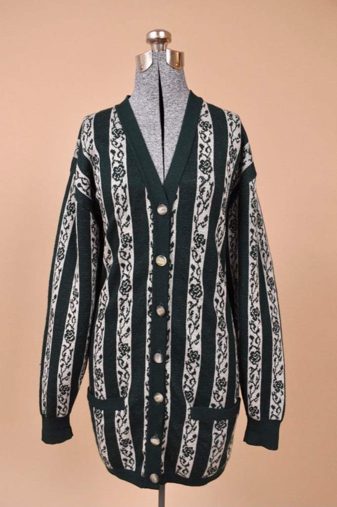 Vintage 1980's green and white vertical stripe long cardigan is shown from the front. This button up cardigan by Jaeger is made from lambswool. 