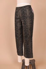 Load image into Gallery viewer, Vintage 90s faux snakeskin print flare capri pants are shown from the side. These funky capris have a low rise fit. 
