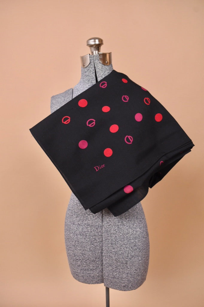 The scarf is folded into a square on the mannequin.