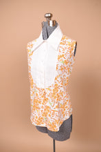 Load image into Gallery viewer, Vintage 1970s orange bird print top is shown from the side. This top has a white bib collar with an oversized collar.
