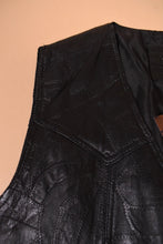 Load image into Gallery viewer, Vintage black leather vest is shown in close up. This vest has stitching over the body of the vest.
