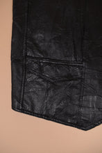 Load image into Gallery viewer, Vintage Y2K black patchwork leather vest is shown in close up. This vest has two front pockets.
