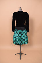 Load image into Gallery viewer, Vintage 1980s Escada black and teal party dress is shown from the back. This dress is made from a silk blend. 
