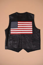 Load image into Gallery viewer, Vintage early 2000&#39;s black leather men&#39;s oversized vest is shown from the back. This vest has an American flag on the back.
