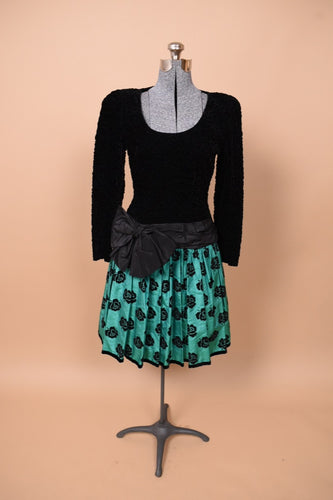 Vintage green and black rose print Escada party dress is shown from the front. This dress has a big bow at the waist. 