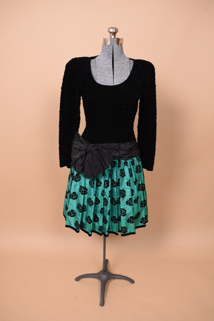 Vintage green and black rose print Escada party dress is shown from the front. This dress has a big bow at the waist. 