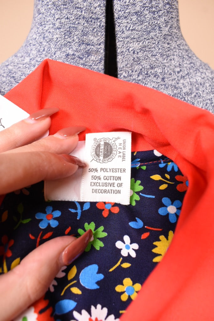 VIntage red smock house dress shown in close up. This house dress has a tag which reads ILGWU.