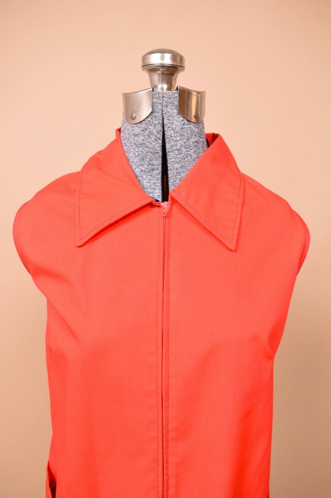 Vintage 70s red house dress shown from close up. The dress has a zipper.