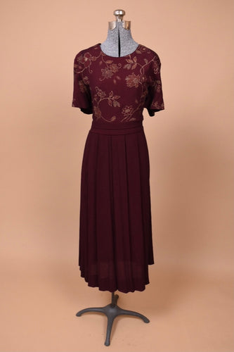 Vintage 1990's burgundy maxi dress is shown from the front. This dress has a floral pattern on the bust.