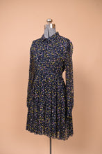 Load image into Gallery viewer, Designer Zadig and Voltaire button front babydoll dress is shown from the side. This dress is navy with a tiny yellow and purple star print.
