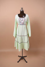 Load image into Gallery viewer, Vintage 1970&#39;s mint green handmade prairie dress is shown from the front. This dress has a midi length tiered skirt.
