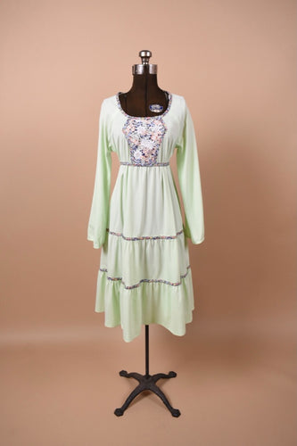 Vintage 1970's mint green handmade prairie dress is shown from the front. This dress has a midi length tiered skirt.